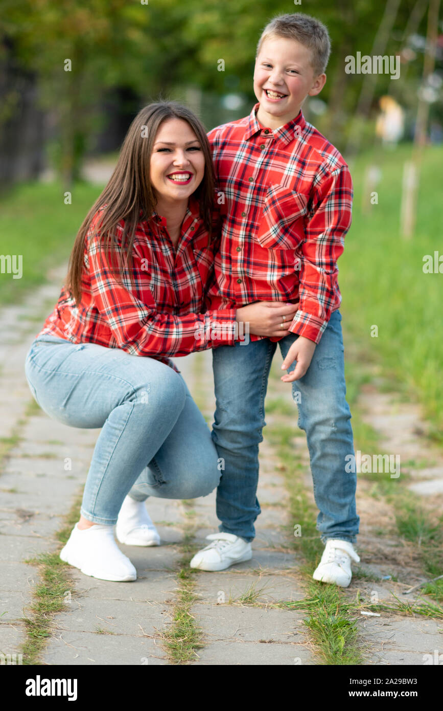 Mom and son are smiling happily on a walk in the park. Stock Photo