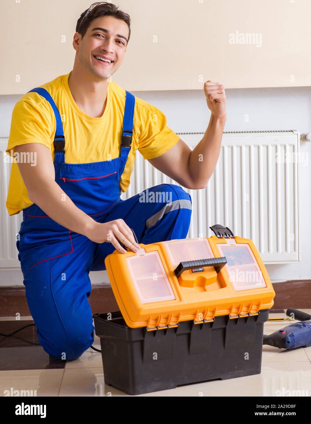 Young repairman contractor repairing heating panel Stock Photo