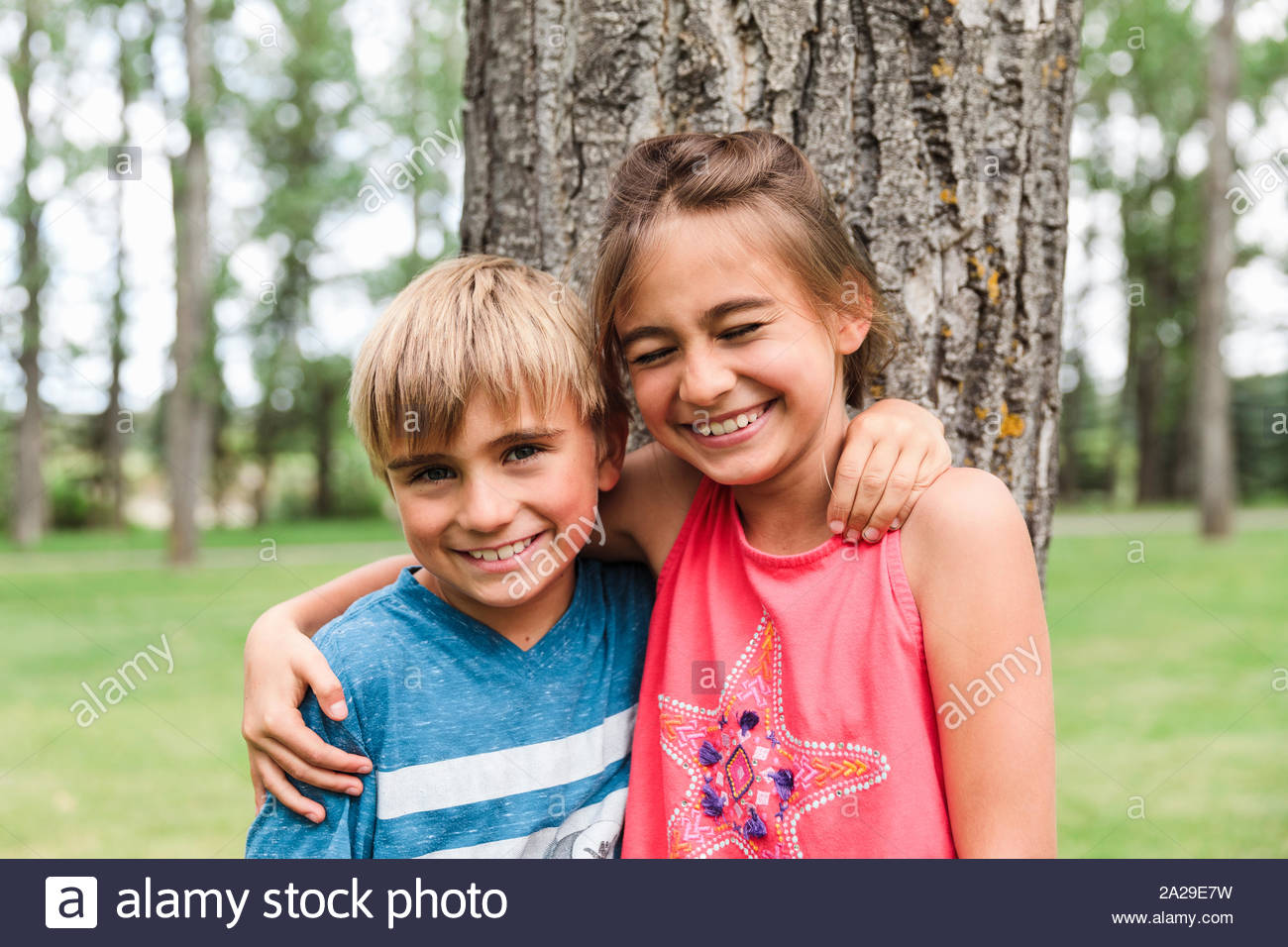 Portrait of brother and sister with arms round each other smiling Stock ...