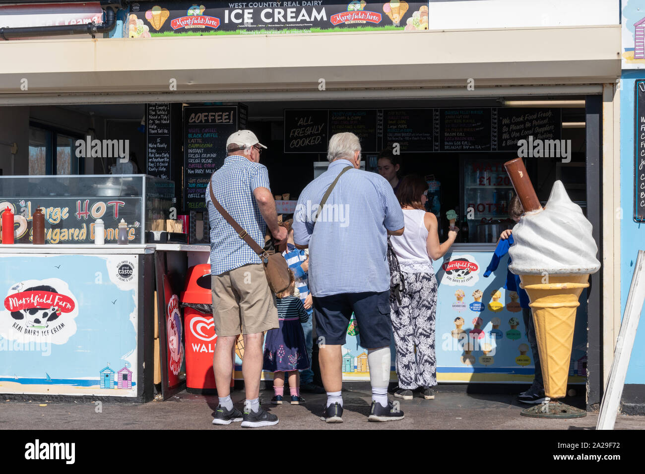 People queuing to buy an ice cream at a seaside food kiosk Stock Photo