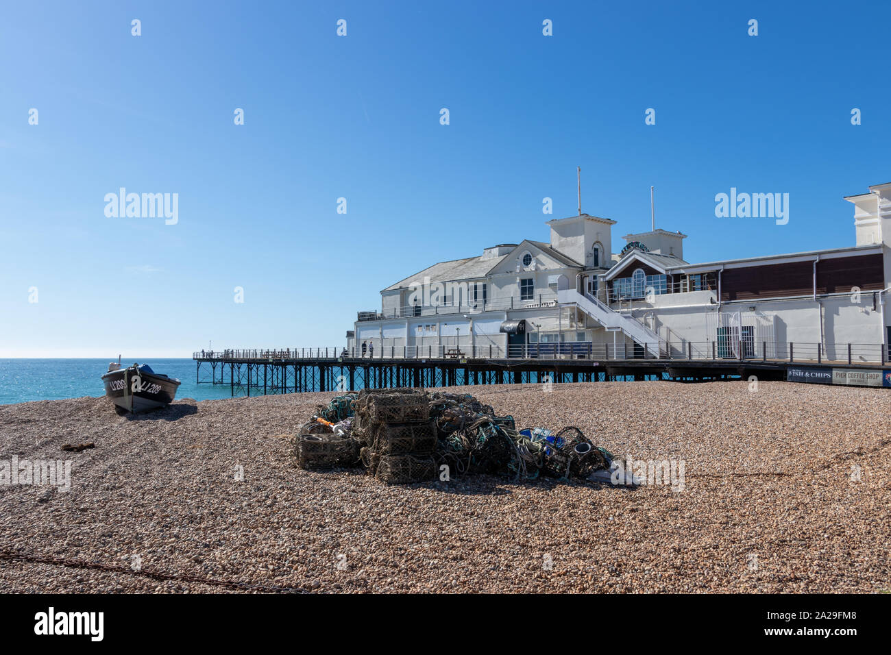 Bognor Regis pier with fishing nets and lobster pods in the foreground on the pebble beach Stock Photo