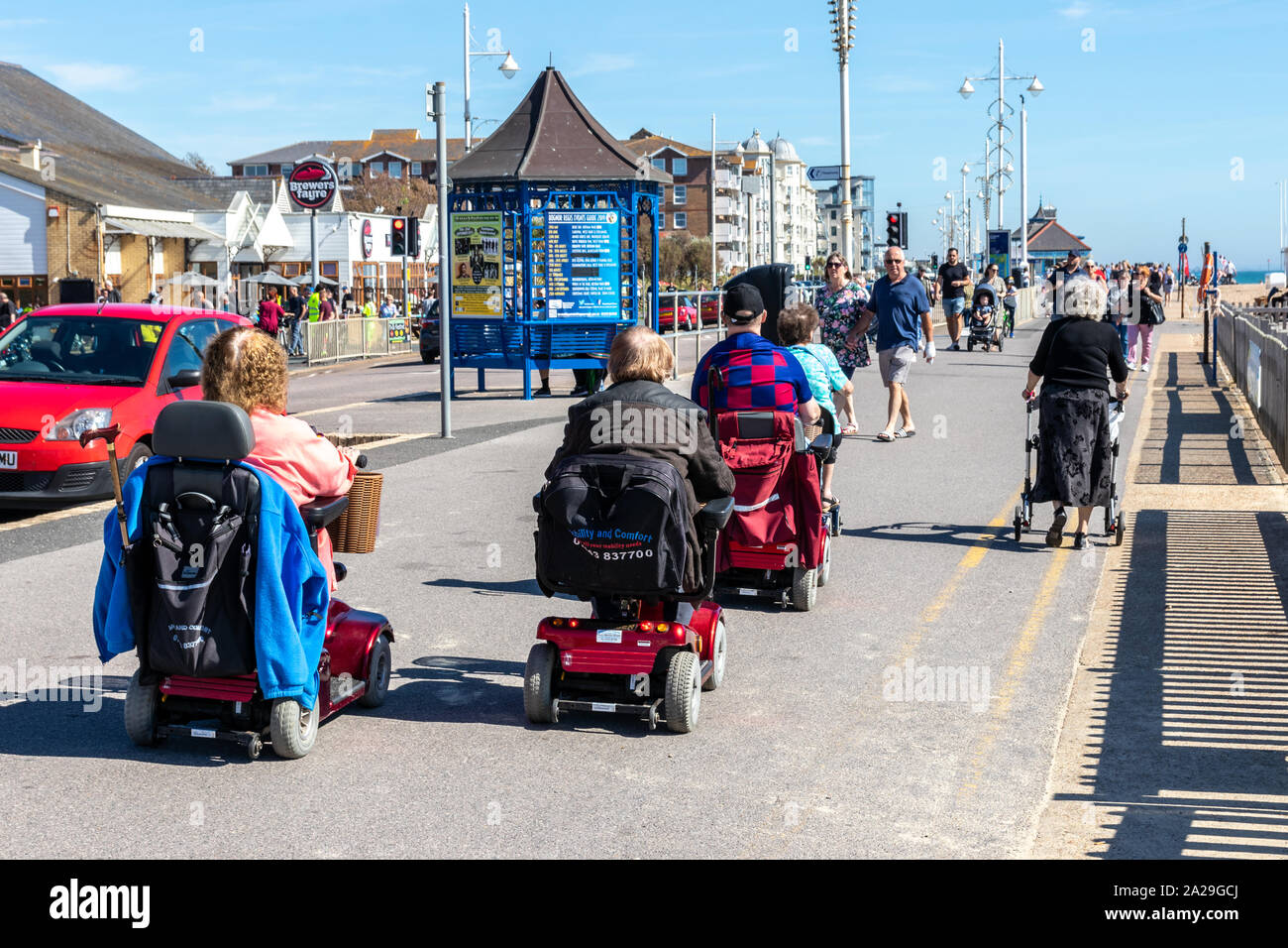 Elderly disabled people on mobility scooters on the promenade of a