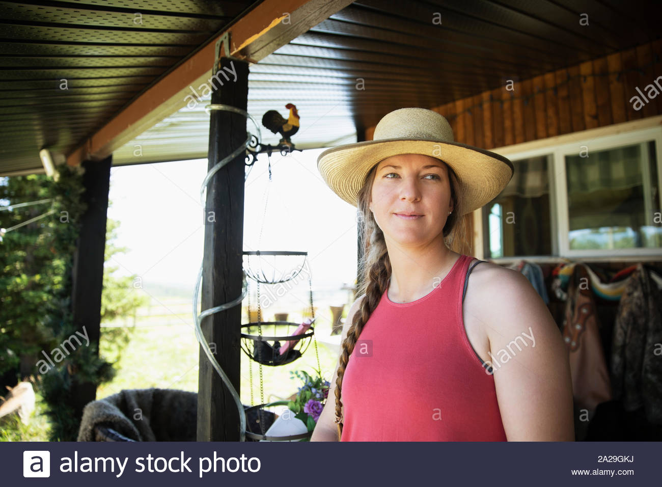 Woman wearing straw hat on ranch Stock Photo