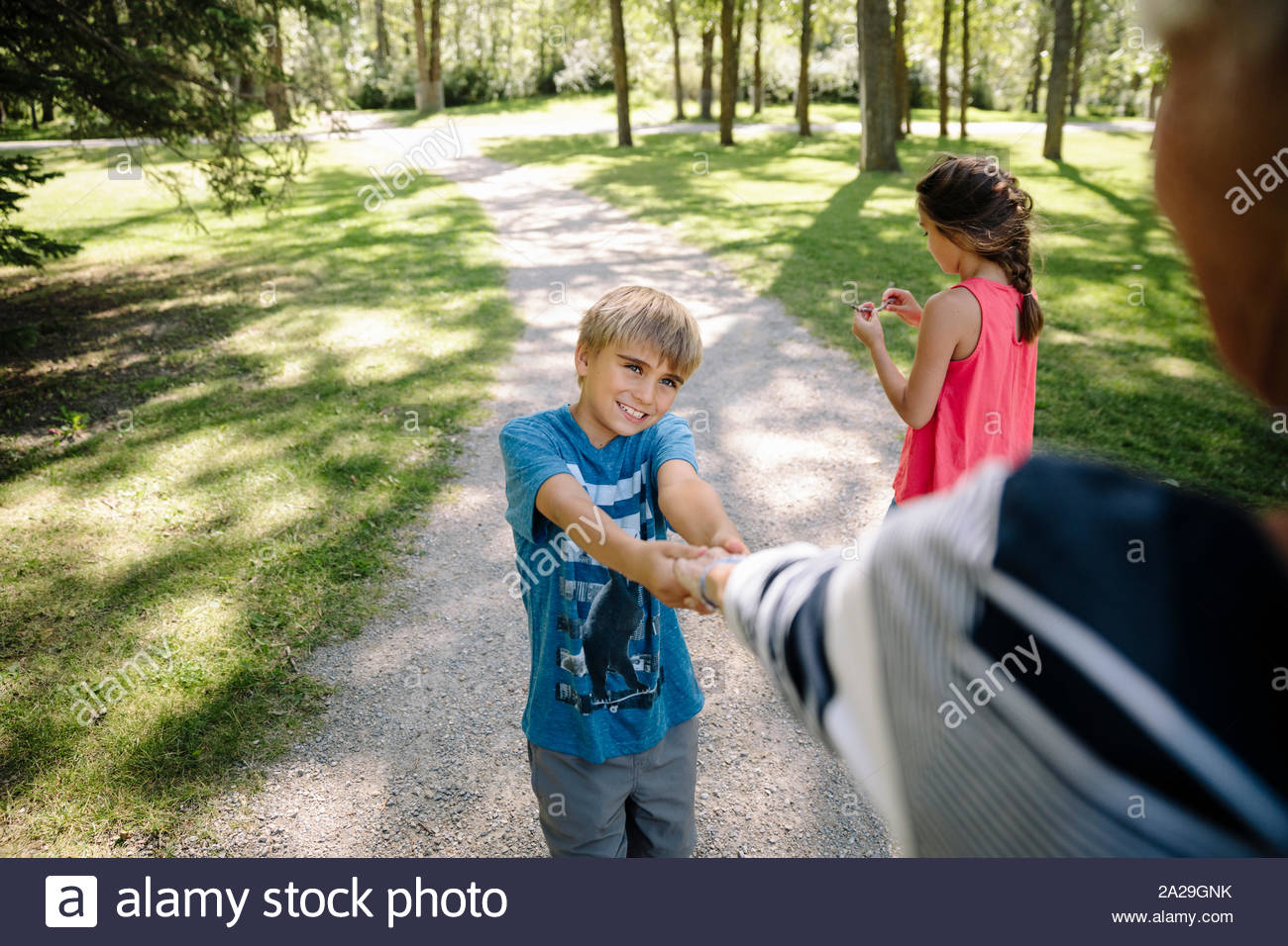 Grandson holding grandmother's hand in urban park Stock Photo