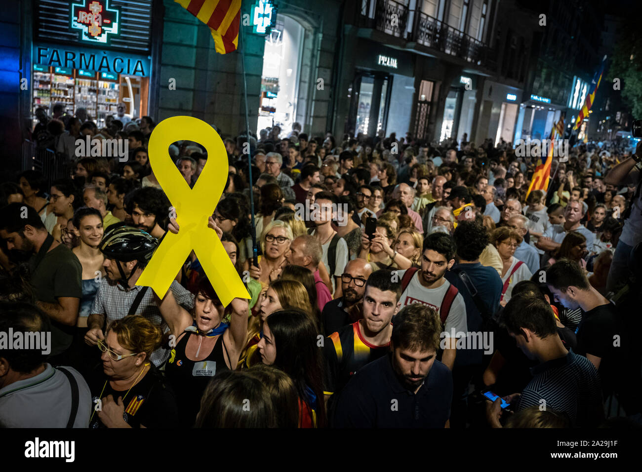 A protester holds a yellow ribbon during the demonstration.Convened by the sovereign entity Assemble Nacional Catalana (ANC) about 20,000 people have come out to demonstrate with the slogan Ho vam fer i  vam Guanyar (we did it and won) to commemorate the second anniversary of citizen resistance during the Referendum of October 1, 2017. Stock Photo