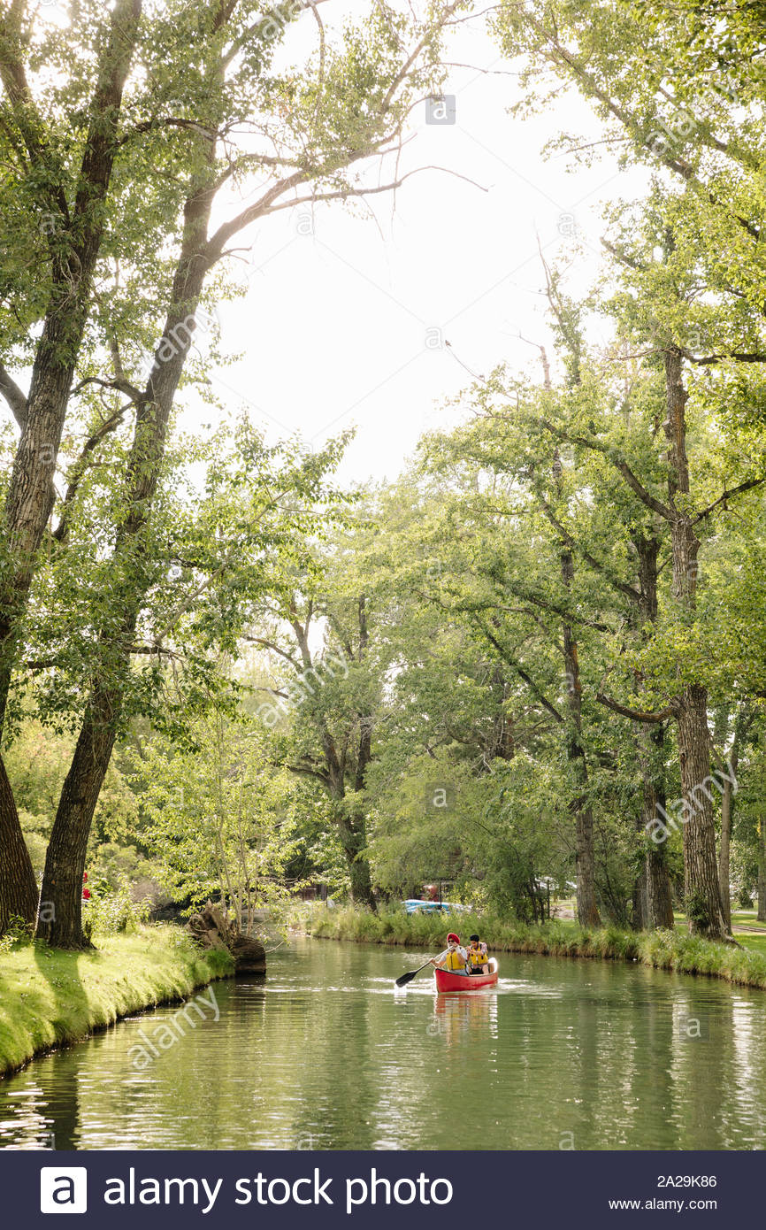 Mature Indian man and son canoeing on lake Stock Photo