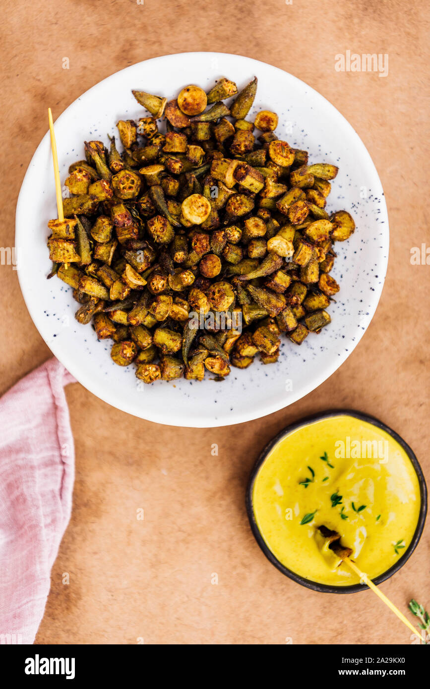 Oven roasted okra chips served with a vegan turmeric tahini dip sauce