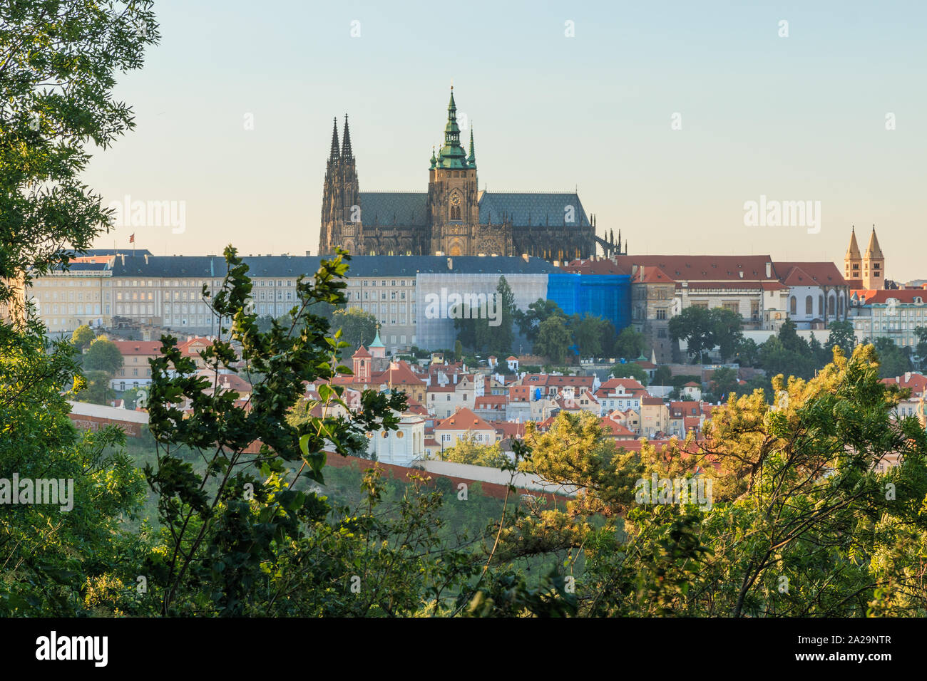 Panoramic view of Prague Castle with the St. Vitus Cathedral above the rooftops of the Mala Strana district from Petrin viewpoint on sunny day with bl Stock Photo
