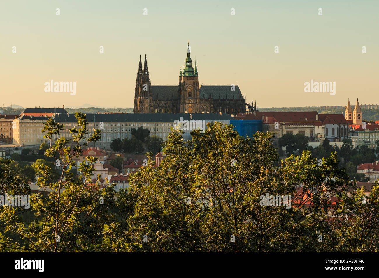 Panoramic view of Prague Castle with the St. Vitus Cathedral over the rooftops of the district Mala Strana from the viewpoint Petrin on sunny day with Stock Photo