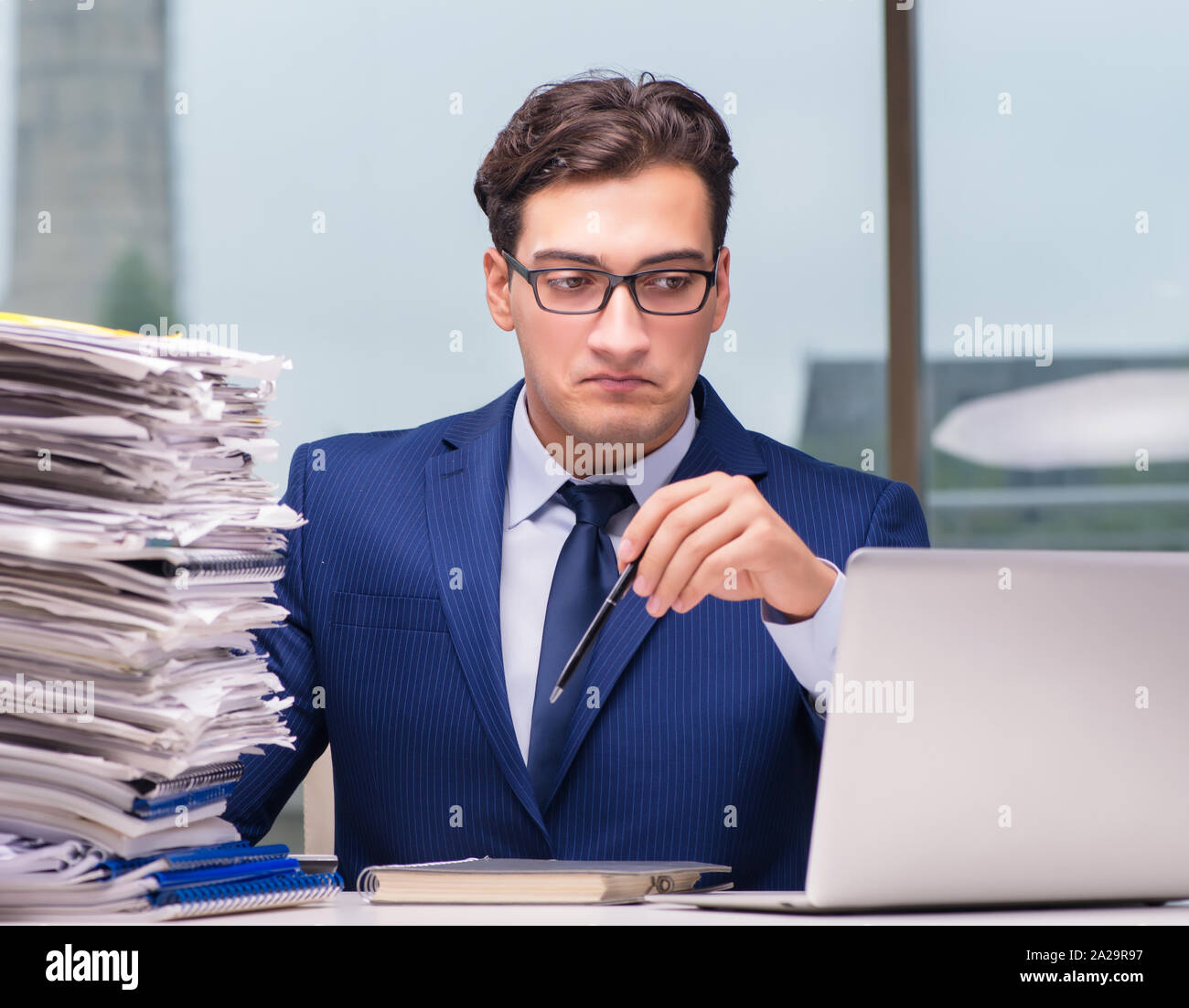 The workaholic businessman overworked with too much work in office ...