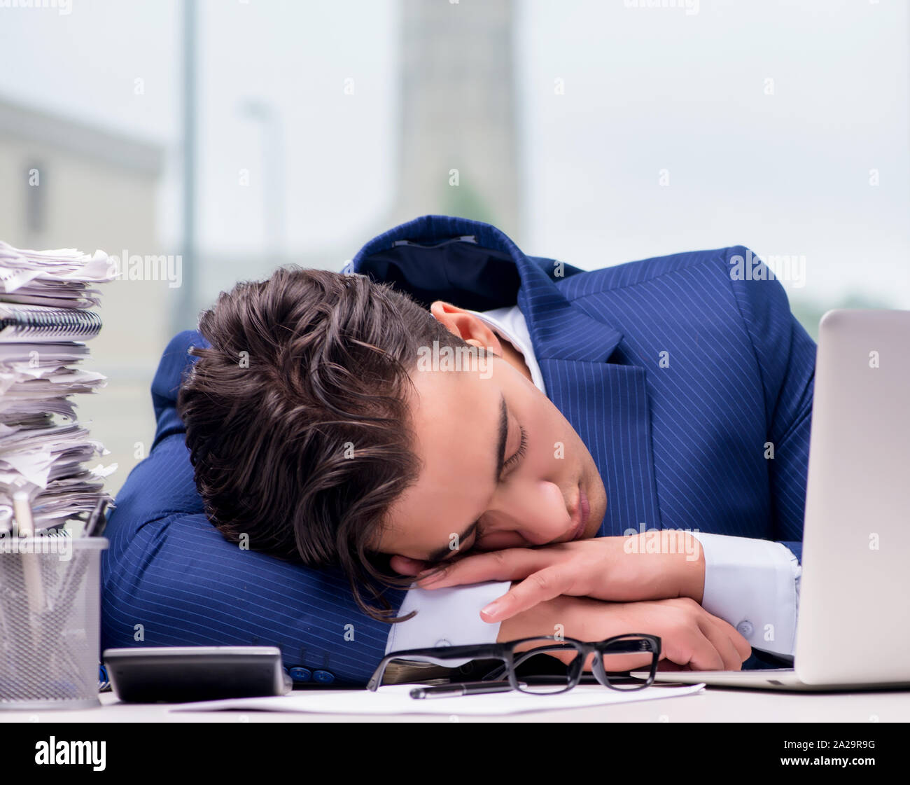The workaholic businessman overworked with too much work in office ...