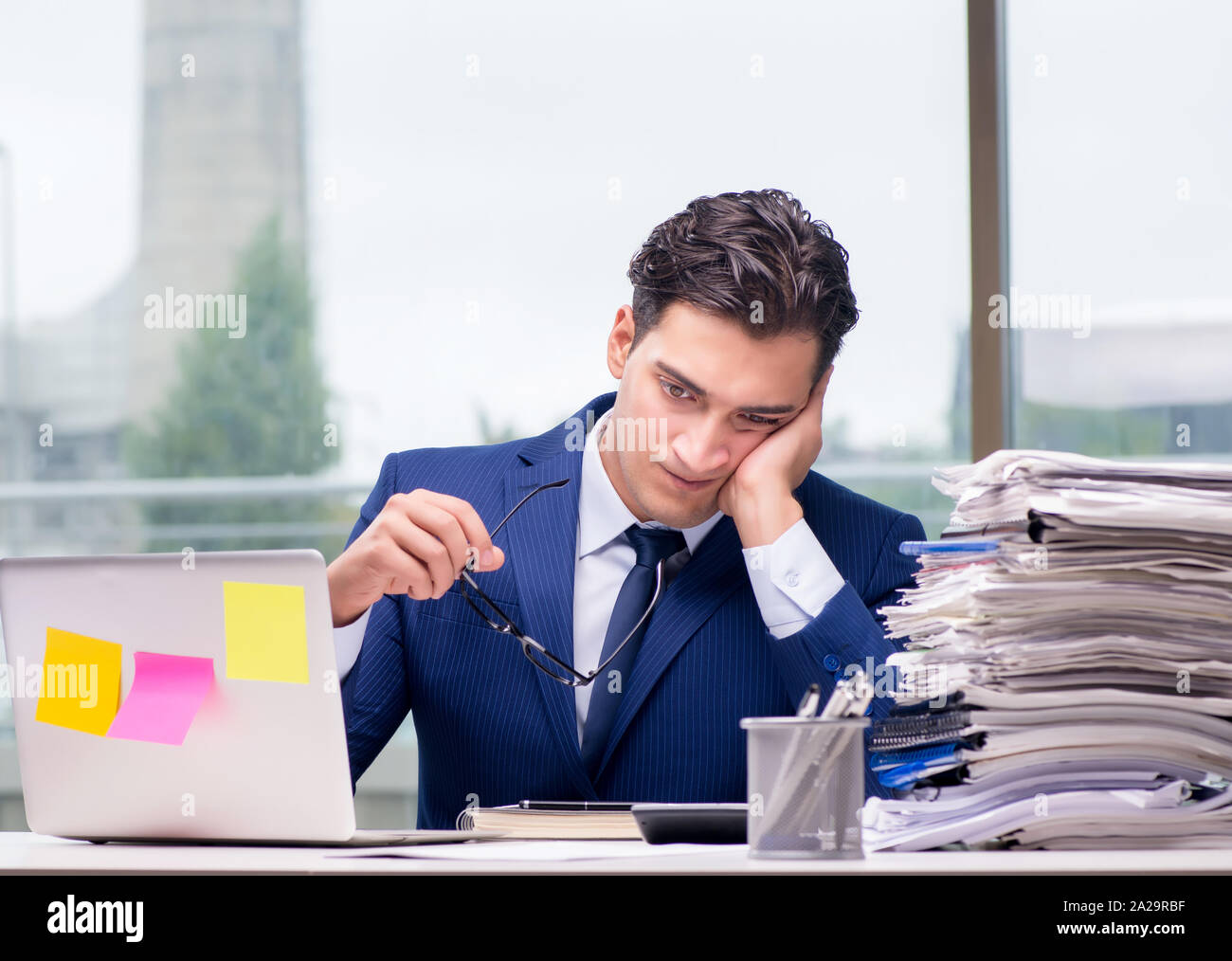 The workaholic businessman overworked with too much work in office ...