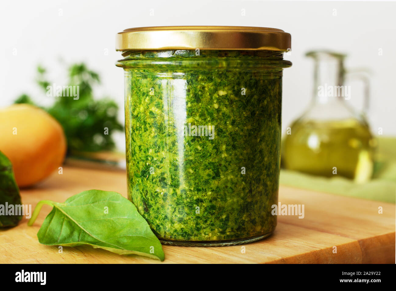 Homemade pesto sauce in a glass jar with basil, ingredients and baguette on  white table in the kitchen. Pesto - traditional italian sauce for Stock  Photo - Alamy