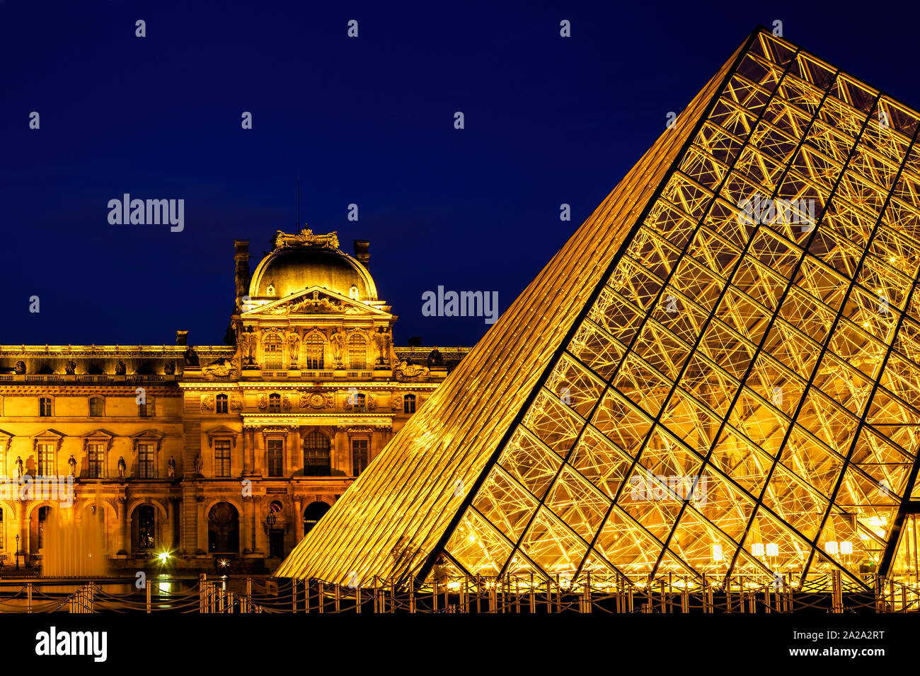 The Louvre and Pyramid illuminated at night Stock Photo