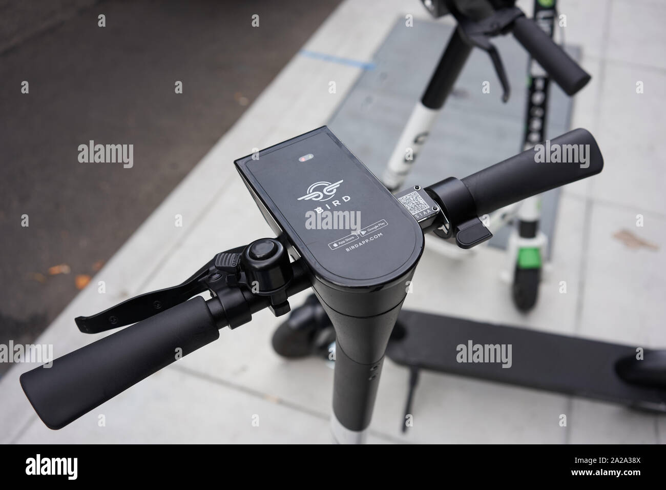 Portland, Oregon, USA - Sep 13, 2019: Closeup of handlebars of a BIRD branded dockless shared electric scooter parked by the roadside in downtown. Stock Photo