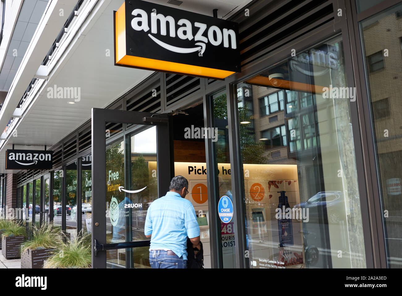 Portland, Oregon, USA - Sep 13, 2019: A man enters an Amazon Hub Locker location, a self-service delivery place to pick up and return Amazon packages. Stock Photo