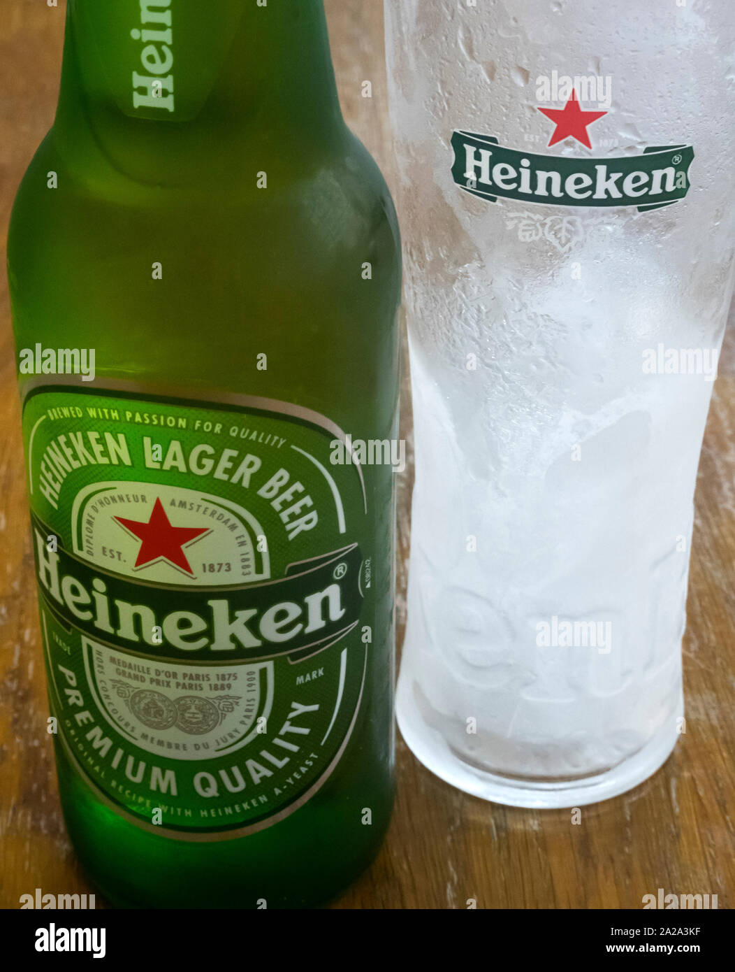 A Heineken beer bottle next to a frosted glass Stock Photo