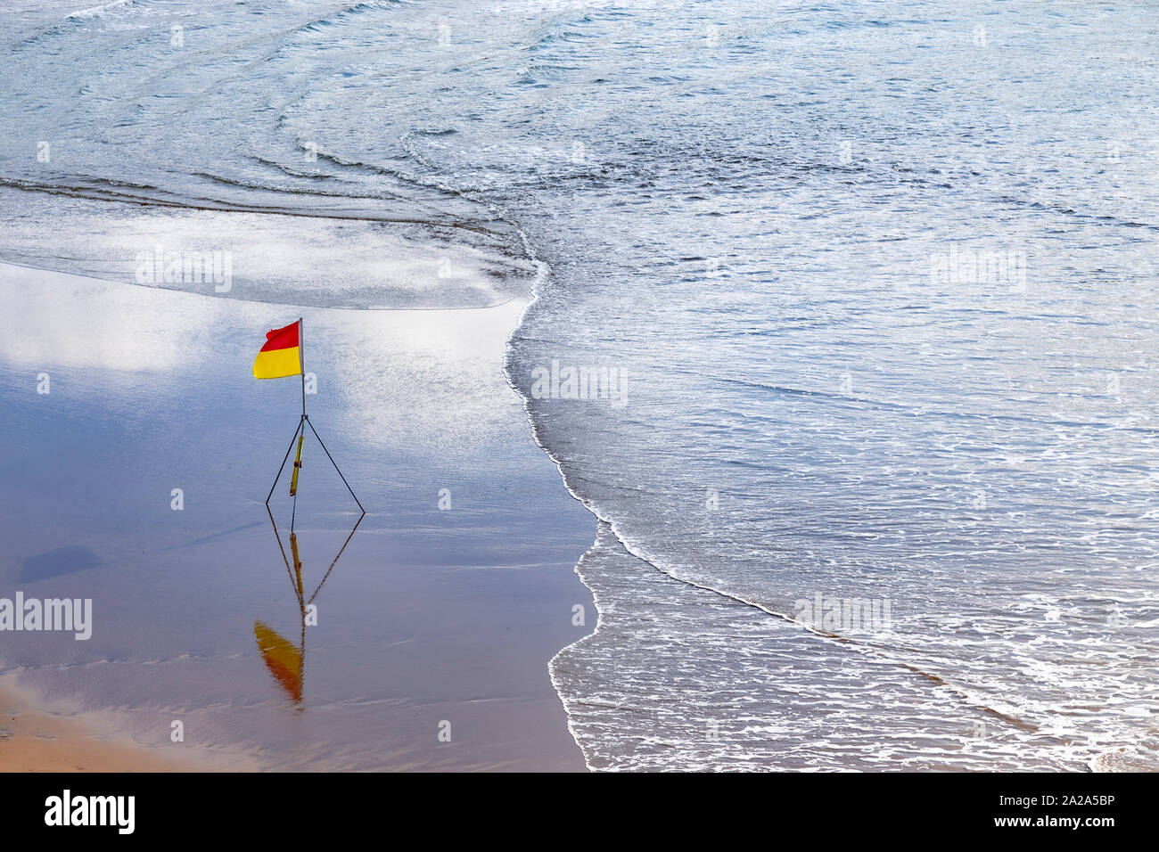 Warning flag on wet sand at Bude on the North Cornwall coast Stock Photo