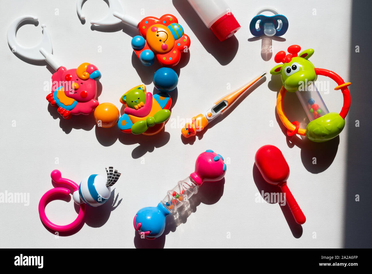 Colorful baby rattles on a white background. Contrasting shadows top ...