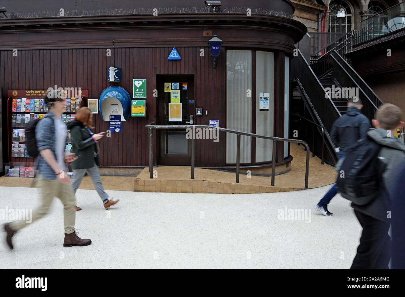 Railway passengers walk past the British Transport POlice station at Glasgow Central Station, Scotland. Stock Photo