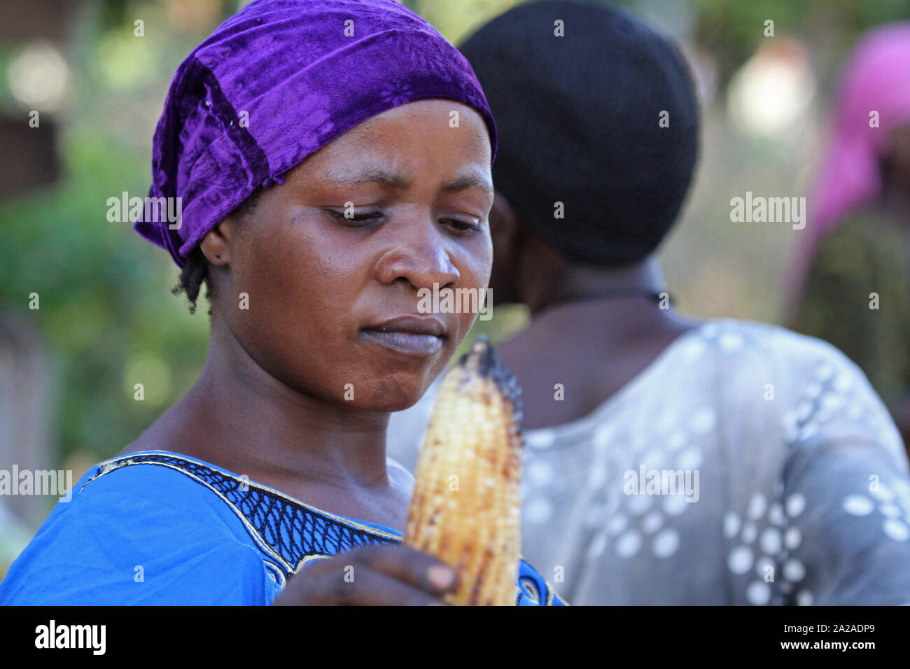 Local African farm woman with burnt corn cob in hand, Zanzibar, Unguja