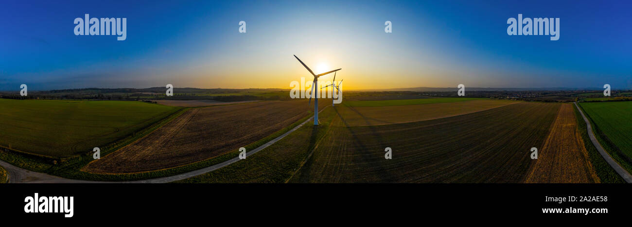 Three large wind turbines at sunrise taken from the air in panoramic ...