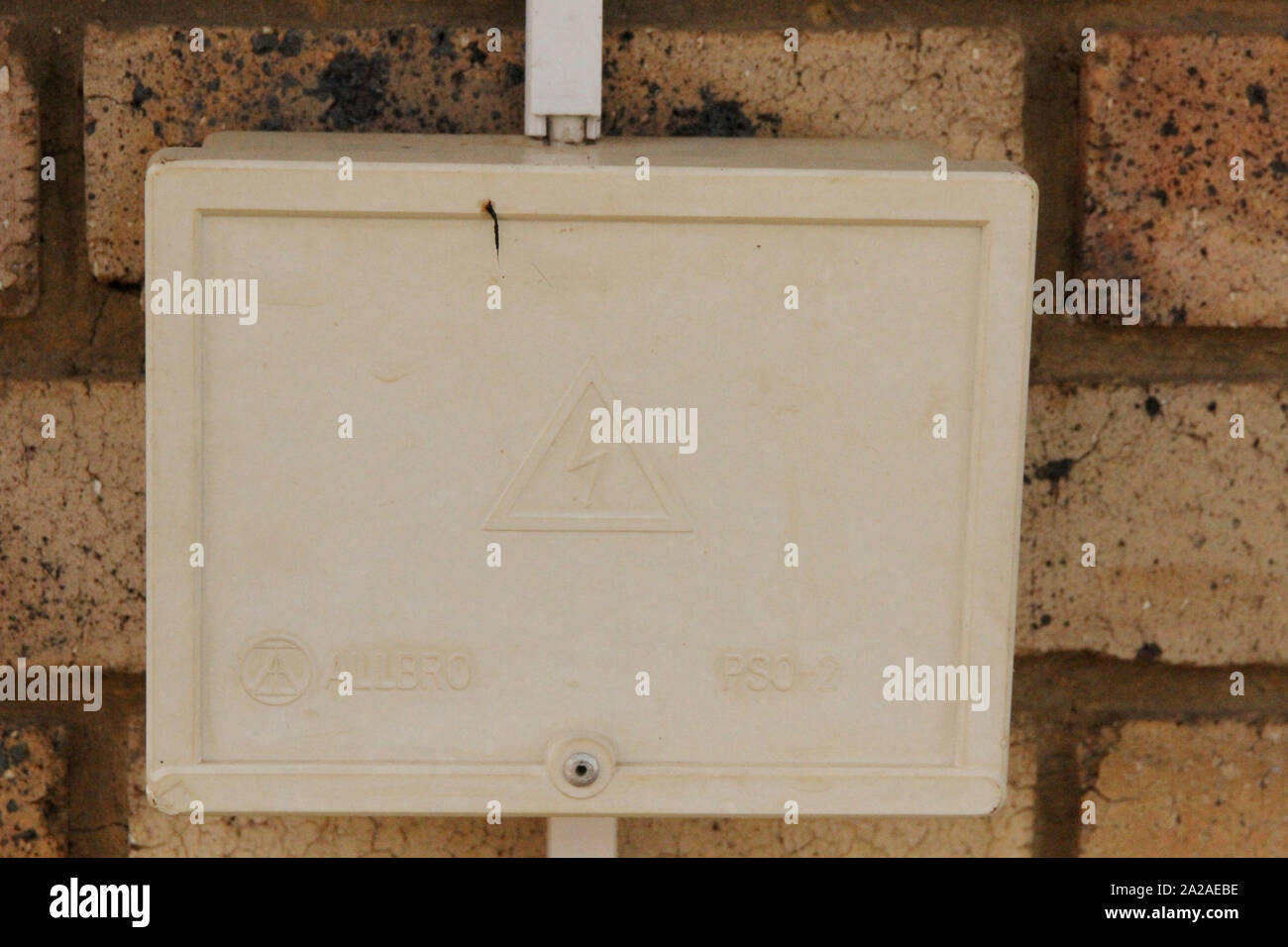 Closed single weatherproof threepoint wall plug socket on brick wall