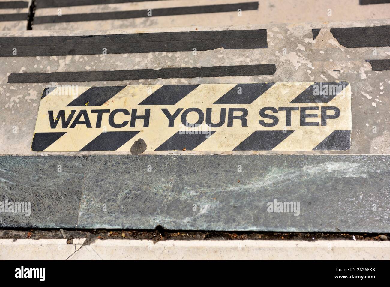 watch your step,warning sign on damaged worn steps Stock Photo