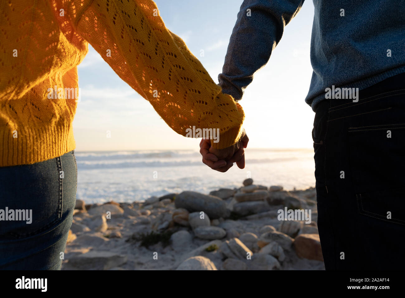 Couple holding hands by the sea Stock Photo - Alamy