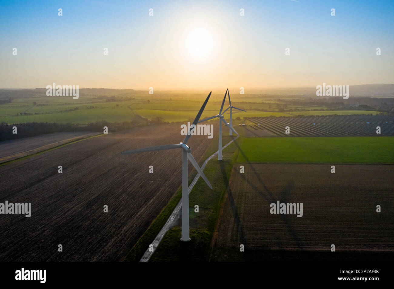 Three large wind turbines at sunrise taken from the air Stock Photo - Alamy