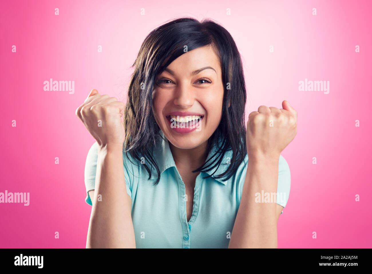 Portrait of enthusiastic happy girl with fists up. Stock Photo