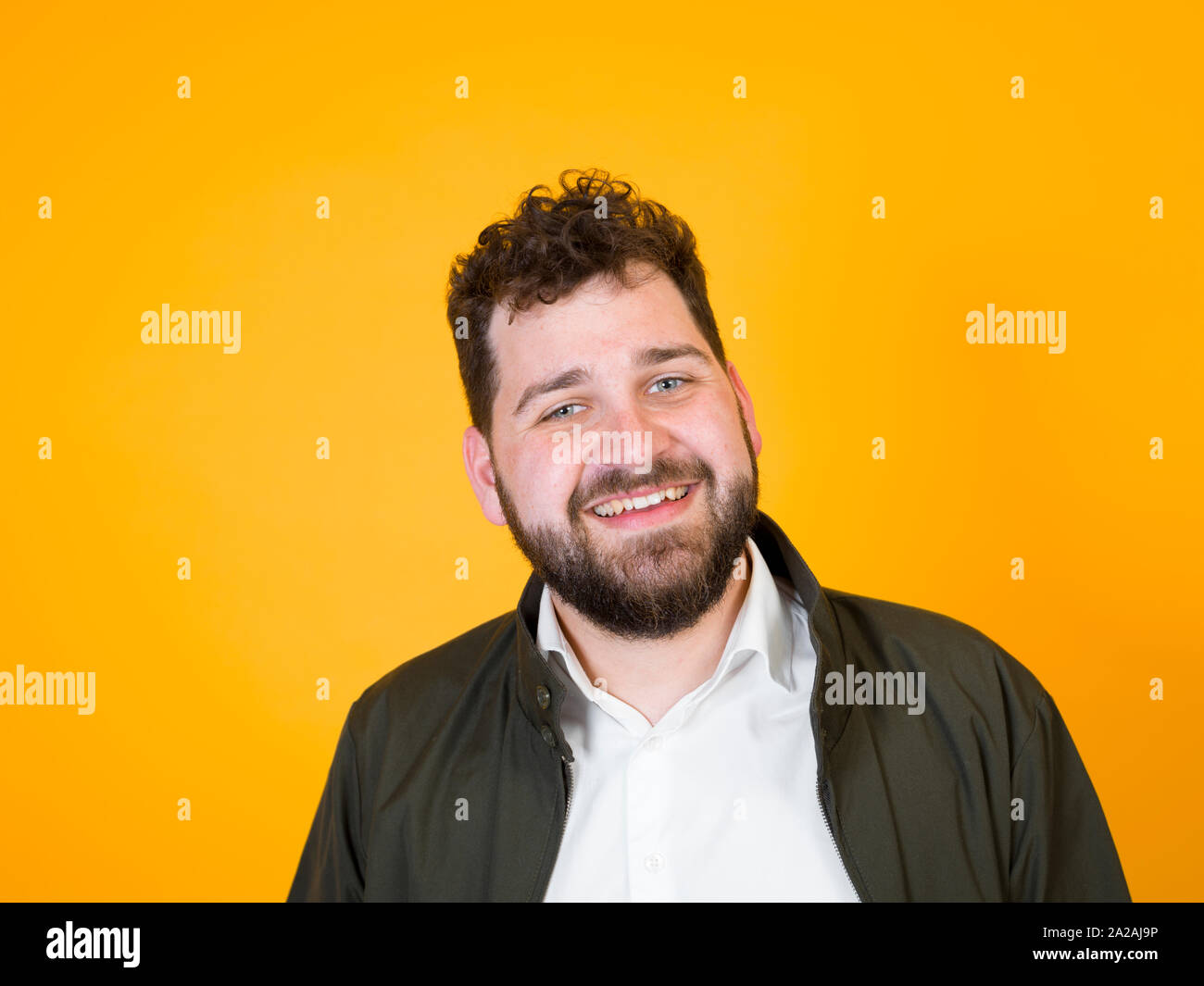 Cool Man With Black Beard And Black Hair Is Posing In Front Of