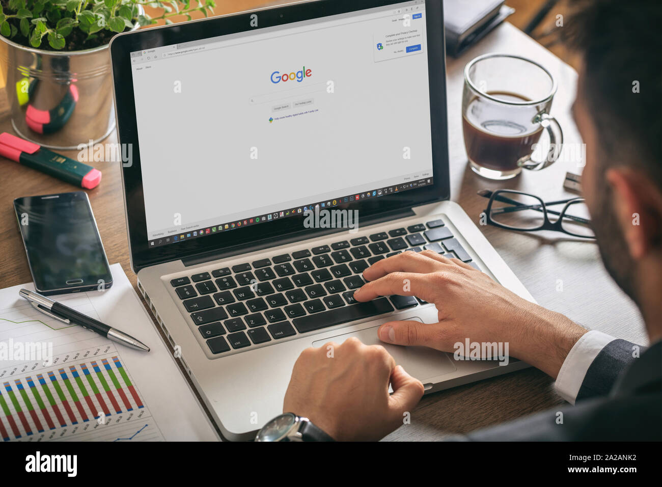 Athens, Greece. September 18, 2019. Young man working with a laptop, Google search engine on the computer screen, office workspace Stock Photo