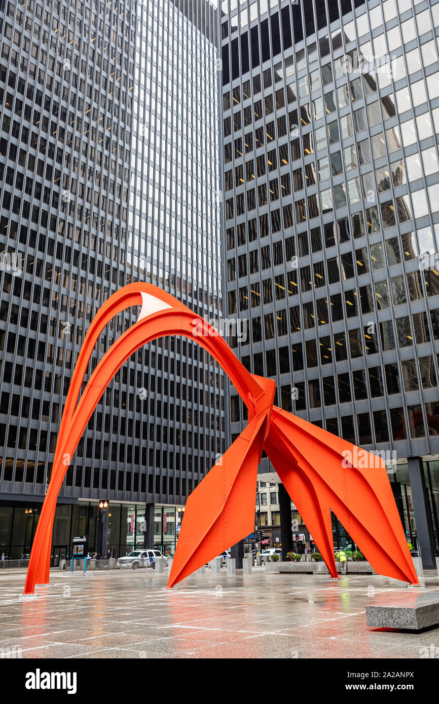 Chicago, Illinois, USA. May 9, 2019. Red Flamingo art sculpture between office buildings exterior at Federal Plaza, Skyscrapers with mirror windows ba Stock Photo