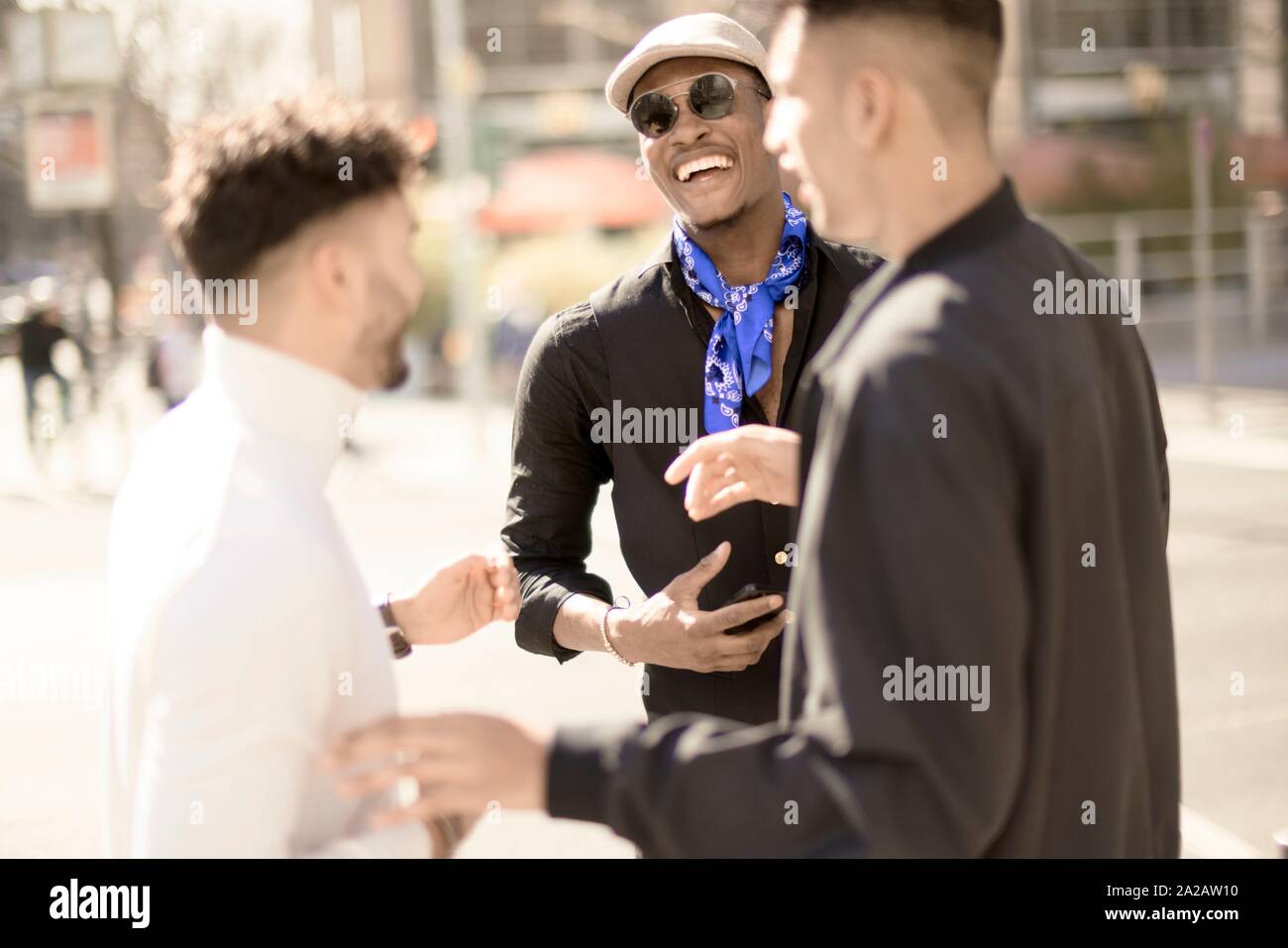 three male friends discussing on street in city Frankfurt, Germany Stock Photo