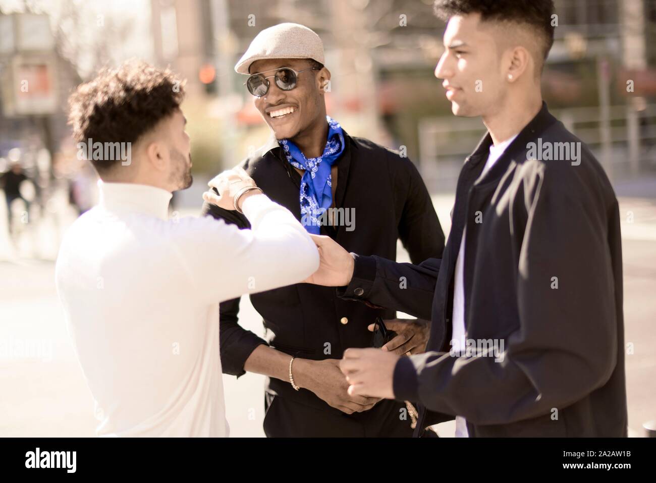 three male friends discussing on street in city Frankfurt, Germany Stock Photo