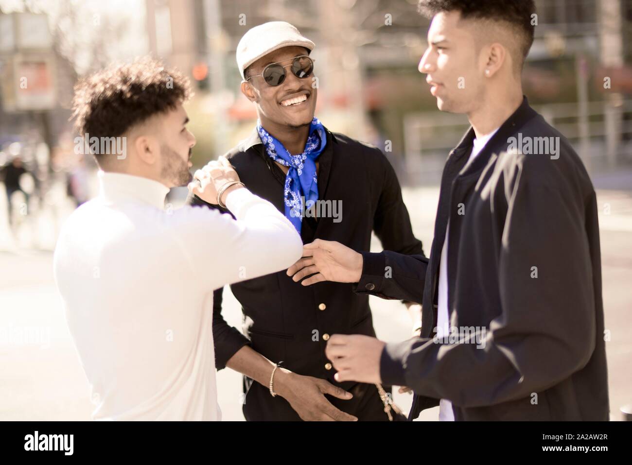 three male friends discussing on street in city Frankfurt, Germany Stock Photo