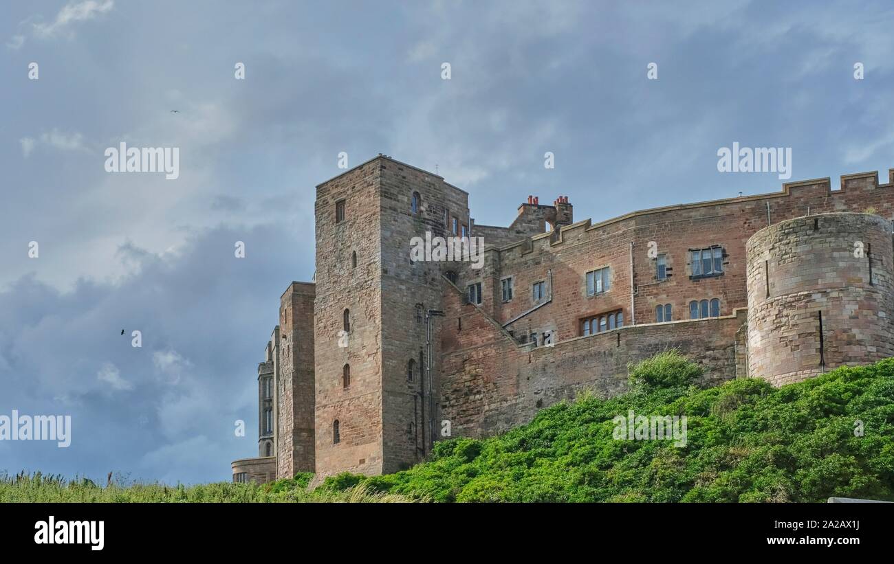 Bamburgh Castle is a castle on the northeast coast of England, by the village of Bamburgh in Northumberland. It is a Grade I listed building.The site Stock Photo