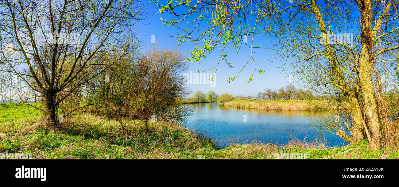 Landschaft im Frühling mit Fluss bei strahlendem Sonnenschein Stock Photo
