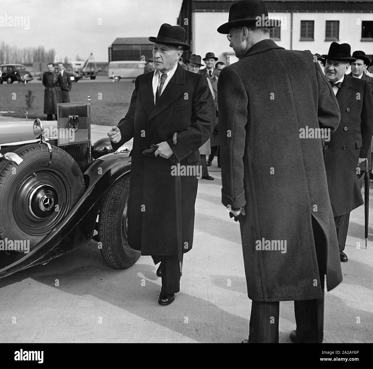 Chancellor Konrad Adenauer (in front of his official car) and the French High Commissioner in the Federal Republic of Germany, Andre Francois-Poncet (right with hat and bow tie) at the Cologne airport from where they will fly to Paris together. Stock Photo