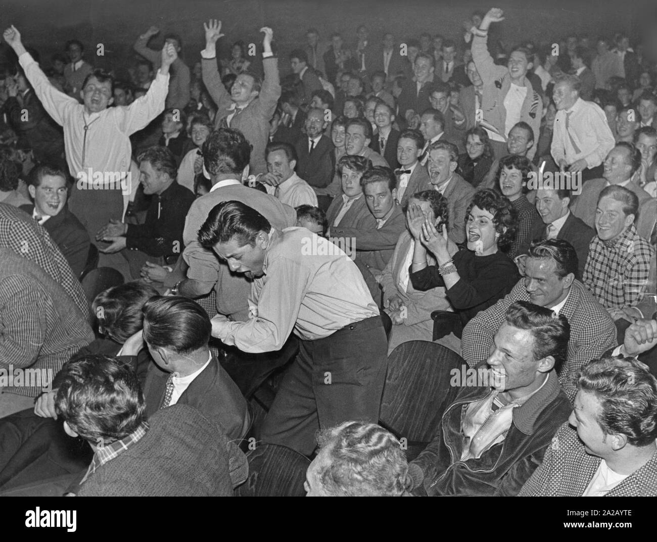 The picture shows a view of the audience of a rock 'n roll concert. The crowd celebrates with enthusiasm. Stock Photo
