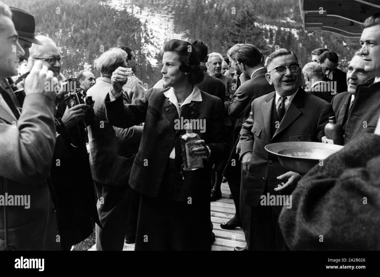 Lilian, the Princess of Réthy (middle), and the Austrian politician Leopold Figl (left) at a chamois hunt in Hinterriss in 1959. The princess holds a shot glass and a bottle in her hands. Stock Photo