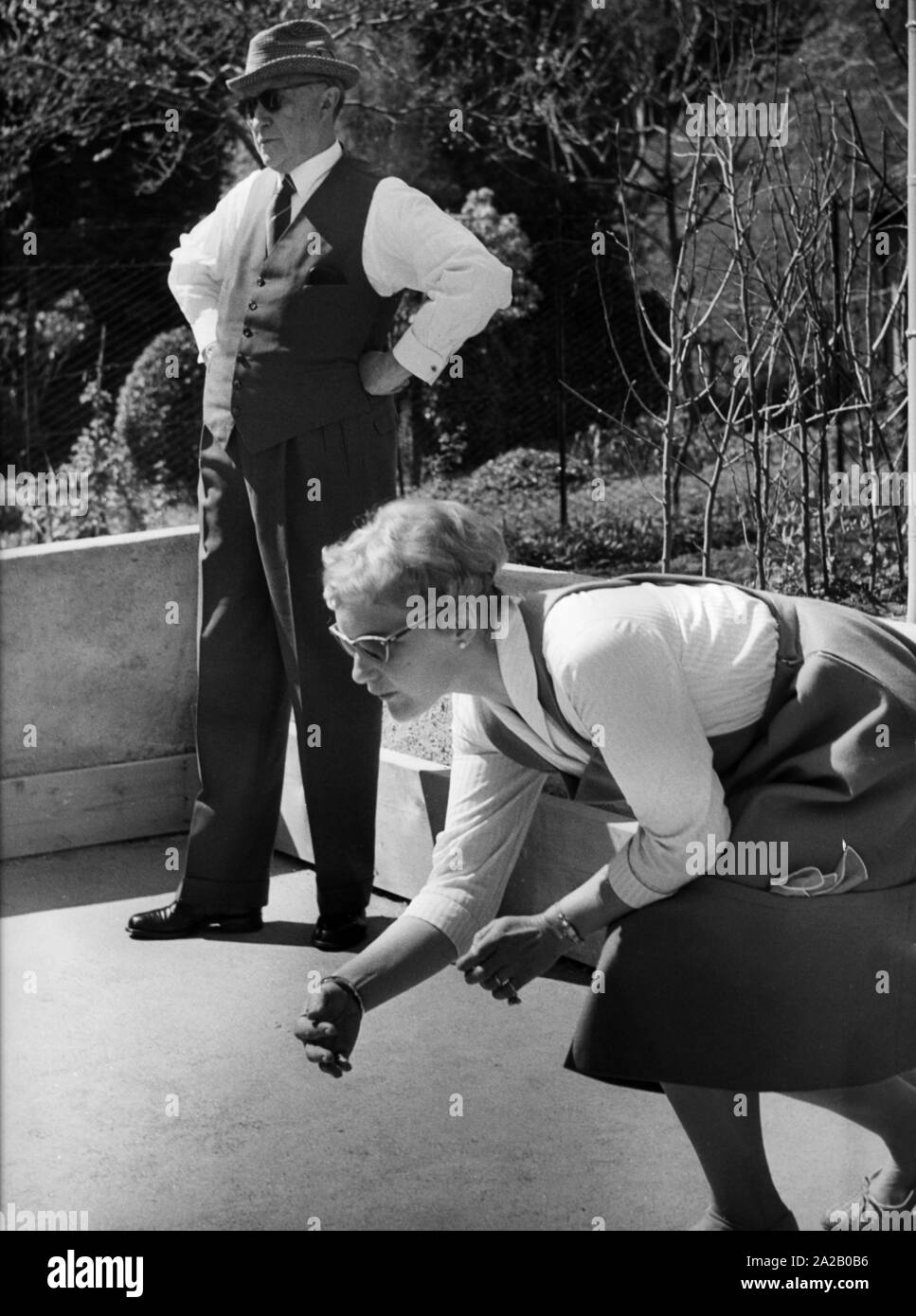 Federal Chancellor Konrad Adenauer plays bocce during his vacation at Villa Arminio in Cadenabbia. He is wearing a pepita hat. In the foreground (presumably) his youngest daughter Elisabeth. Stock Photo