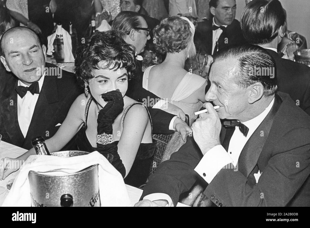 The journalist Georg Salmony and the actress Mara Lane in conversation with the rich industrialist Nuss. In the background the boxer Max Schmeling can be seen. Stock Photo