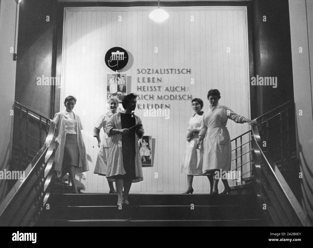 Women in the German Fashion Institute in East Berlin. On the wall you can see the inscription 'Socialist life also means to dress fashionably'. Stock Photo