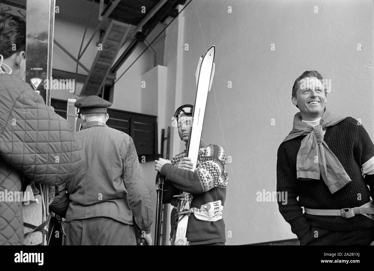 Photo of ski racer Toni Sailer with his skis at the cable car station, which goes up to the Hahnenkamm. He took part in the ski race held there in January 1962. The Hahnenkamm race has been held on the Hahnenkamm in Kitzbuehel since 1931. Stock Photo