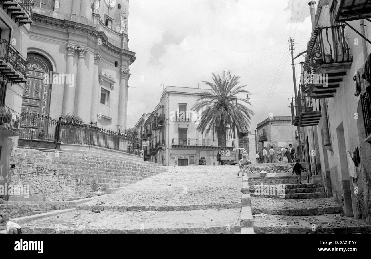 Photo a larger street in Montelepre. On the left, the church of Maria Santissima del Rosario, built in the 15th century. Montelepre in the province of Palermo (region of Sicily) is 26km away from the city of Palermo. Former Sicilian folk hero Salvatore Giuliano was born in Montelepre in 1922, and he is buried in the Ostfriedhof (cemetery) of the city. The inhabitants of Montelepre make a living mainly from farming. Stock Photo