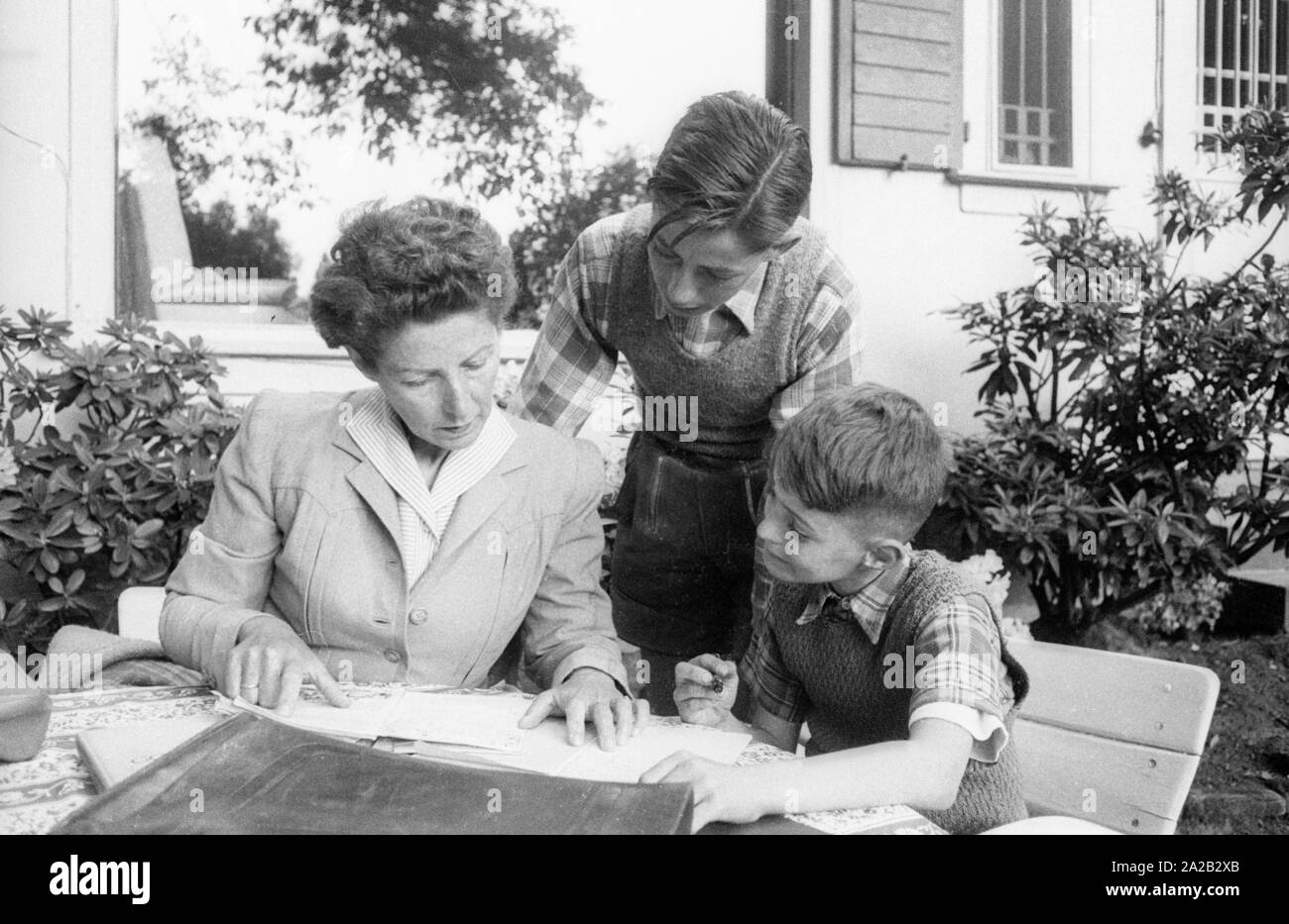 Margarete Speer, wife of Albert Speer, sits with her sons Ernst (right) and Arnold (middle) in the garden of the family villa in Heidelberg. Stock Photo