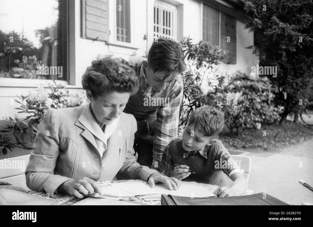 Margarete Speer, wife of Albert Speer, sits with her sons Ernst (right) and Arnold (middle) in the garden of the family villa in Heidelberg. Stock Photo
