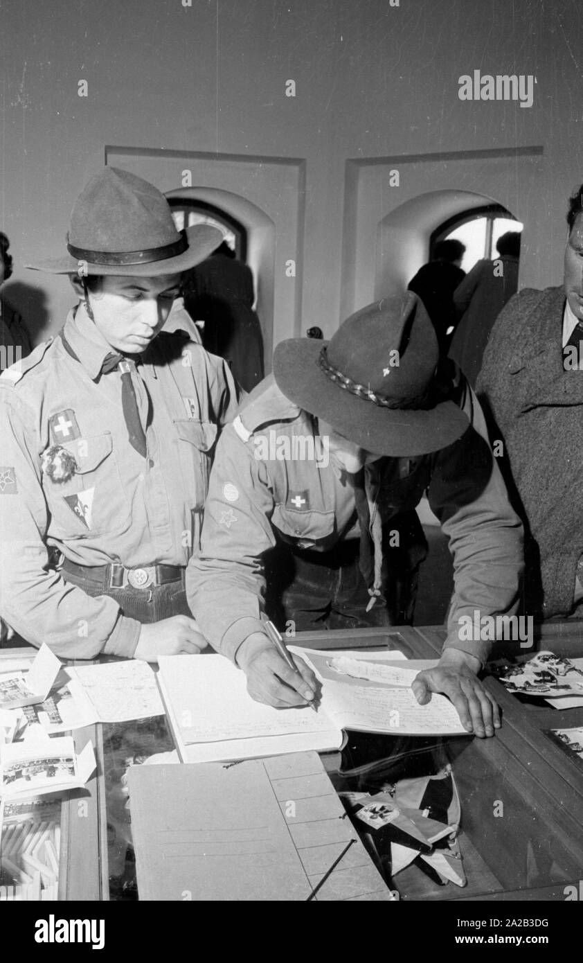 Swiss scouts sign the visitors' book in the south tower of the Munich Frauenkirche. In 1954, a new elevator was installed there that could comfortably bring tourists up to the top. This photo was probably taken on the inauguration day of the elevator. Stock Photo